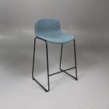 Begagnad barstol Neo från Materia med blågrön klädsel, svart underrede och integrerat fotstöd. Mått: bredd 55 cm, djup 46 cm, höjd 83 cm, sitthöjd 63 cm. 