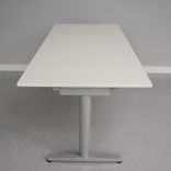 Begagnat höj- och sänkbart skrivbord Galant från Ikea. Laminatskiva i vitt med silverfärgat stativ. Mått: Bredd 160 cm, Djup 80 cm, Höjd justerbar mellan 70 till 120 cm. 