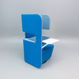 Begagnad fåtölj med hög rygg PodSeat från Martela. I ljusblått/turkos tyg och vit bordsskiva. Mått: bredd 70 cm, djup 65 cm och totalhöjd 126 cm. 
