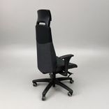 Begagnad kontorsstol Volmar från IKEA i svart och mörkgrått med justerbara armstöd, nackstöd, låsbar gunga. Mått: sitthöjd på 40–54 cm. 