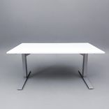 Begagnat höj- och sänkbart skrivbord med kabeldike. I vitt med stativ i silver. Mått: Bredd 140 cm, djup 80 cm, höjd justerbar mellan 70 till 120 cm. 