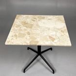 Begagnat cafébord från Audo Copenhagen med bordsskiva i beige/brun sten och svart pelarstativ. Mått: Bredd 60 cm, Djup 70 cm, Höjd 72 cm. 