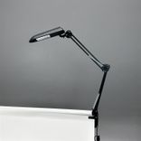 Begagnad skrivbordslampa Verit från Glamox Luxo med klämfäste i svart. Mått: höjd 85 cm.