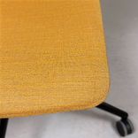 Begagnad stol med hjul Pelican från Johanson Design. Klädsel i senapsgult på svart underrede. Mått: Bredd 55 cm, Djup 50 cm, Sitthöjd justerbar från 43 till 54 cm.  