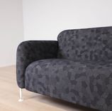 Begagnad 3-sits soffa Mega från Massproductions. Mått: längd 230 cm, höjd 78 cm. Med runda sidopaneler av vitt stål som omger och lyfter de svartmönstrade dynorna. 