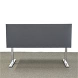 Begagnad bordsskärm, rektangulär i mörkgrått. Mått: längd 80 cm, höjd 60 centimeter. Denna produkt erbjuder visuell avskildhet samt ljudabsorption, perfekt anpassad för kontorsmiljö.
