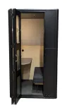 Begagnat telefonbås i svart/grå/trä. Med skjutdörrar i frostat glas, integrerad sittplats/bord, dubbla USB/eluttag. Mått: Höjd 215 cm x Bredd 115 cm x Djup 115 cm. 
