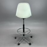 Begagnad stol med hjul Eames Plastic Side Chair PSCC från Vitra. Med blå klädsel, vit sitsskål och kromat underrede. Mått: Justerbar sitthöjd 74 - 86 cm.