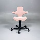 Begagnad kontorsstol med sadelsits Capisco 8106 från HÅG i rosa tyg. Mått: Justerbar sitthöjd 47 - 65.5 cm. 