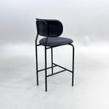 Begagnad barstol Coco från GUBI i svart läder med svartlackerade ben, ryggstöd och integrerat fotstöd. Mått: Bredd 51 cm, djup 52 cm, höjd 98 cm och sitthöjd 65 cm. 
