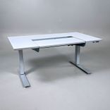 Begagnat höj- och sänkbart skrivbord Dynadesk från Work Motions. Bordsskiva i grå/vit. Mått: Bredd 140 cm, djup 80 cm, justerbar höjd från 70 till 120 cm. 