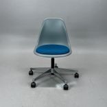 Begagnad stol med hjul Eames Plastic Side Chair PSCC från Vitra med grått plastskal, blå sittdyna, kromat underrede. Mått: Bredd 46,5 cm, djup 55 cm, höjd 76–88,5 cm. 