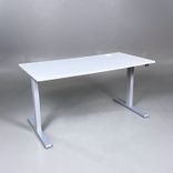 Begagnat höj- och sänkbart skrivbord. Bordsskiva är ljusgrå med stativ i silver. Mått: Bredd 140 cm, Djup 70 cm, justerbar höjd mellan 70 till 120 cm. 