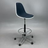Begagnad stol med hjul Eames Plastic Side Chair PSCC från Vitra. Med blå klädsel, vit sitsskål och kromat underrede. Mått: Justerbar sitthöjd 74 - 86 cm.